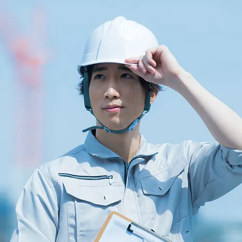 被ったヘルメットに手をかける男性スタッフ